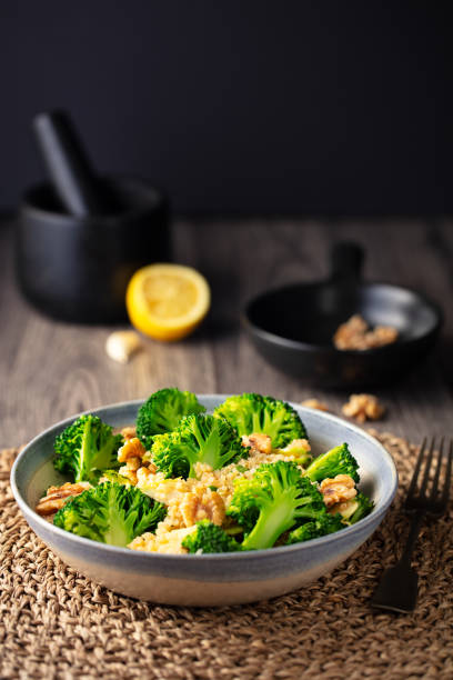 insalata di quinoa di broccoli sani con noci - healthy eating close up lemon nut foto e immagini stock