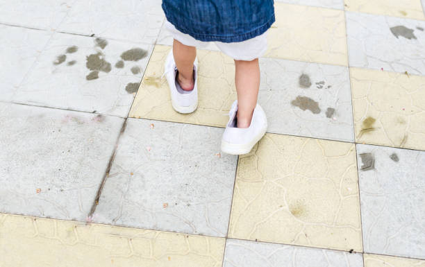 istock Child feet in white huge sneakers. 1163932322