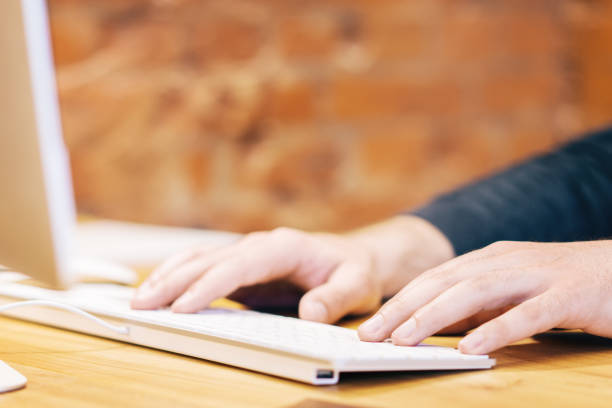 istock Sideview of businessman hands using keyboard 1163934424