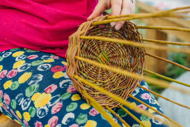 istock woman hands manually weaving willow twigs. 1163934472