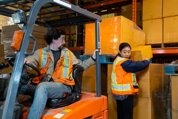 istock An industrial warehouse workplace safety topic. A worker in the danger zone, working behind a forklift carrying a load. 1163934947