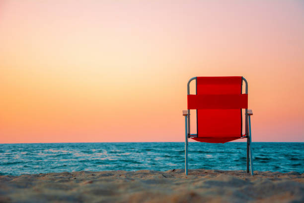 빨간 일몰과 해변에서 빨간 의자 - lifeguard orange nature beach 뉴스 사진 이미지