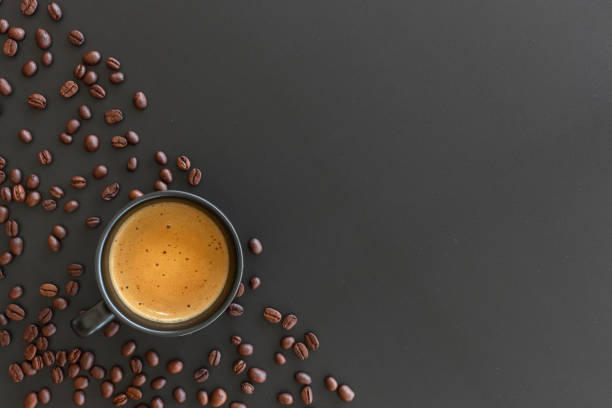 istock hot espresso and coffee bean on black table with soft-focus and over light in the background. top view 1163939922