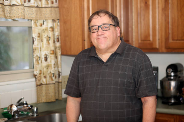 istock A man with learning difficulties and autism complete different tasks around the house. 1163942782