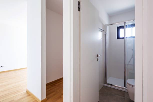 istock Modern minimalist white bathroom with shower and small window 1163942798