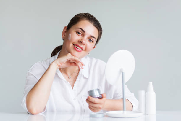 istock Beautiful elegant woman applying cream on face 1163942888