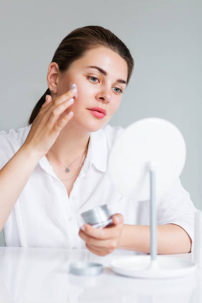 istock Beautiful elegant woman applying cream on face 1163942890