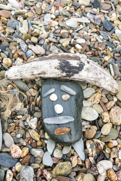 istock Simpatic face created on a beach with stones and small wooden sticks 1163952694