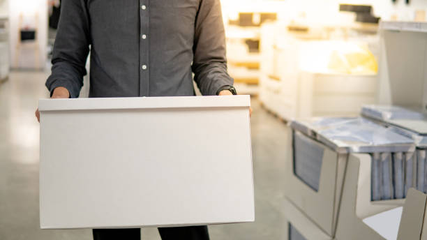 istock Courier man carrying white box in warehouse 1163954171