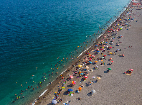 Aerial view of Konyaalti Beach Antalya, Turkey. Crowded beach, umbrellas and people swimming in the sea