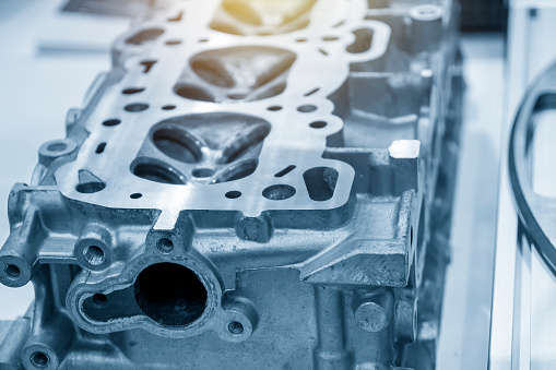 The aluminium cylinder head of the engine in the light blue scene. The automotive parts manufacturing  process.