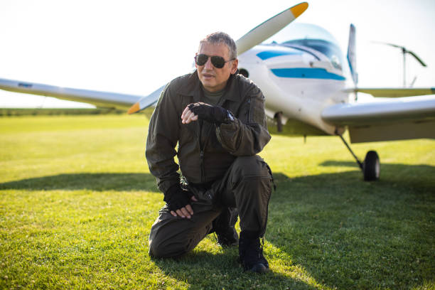 istock Confident pilot crouching in front of private airplane 1163963819