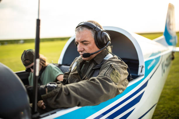 istock Father pilot and daughter sitting in small private airplane 1163964012