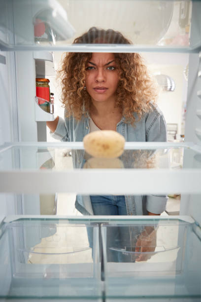 istock Disappointed Woman Looking Inside Refrigerator Empty Except For Potato On Shelf 1163965384
