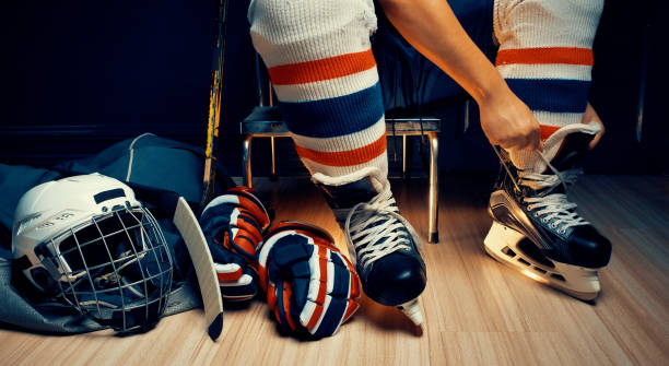 pro hockey sur glace, il cordon de chaussure dans le vestiaire de l'athlète - child winter snow asian ethnicity photos et images de collection