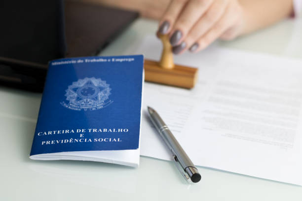 Brazilian work permit A portfolio of Brazilian workers (Translation "Work Permit, Ministry of Labor and Social Security Brazil CTPS"), female hand stamping a work contract background. employment and labor stock pictures, royalty-free photos & images