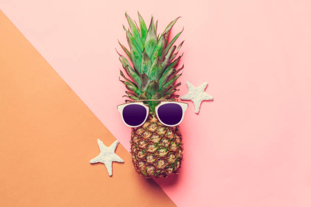 istock pineapple on colored paper with glasses 1163972947