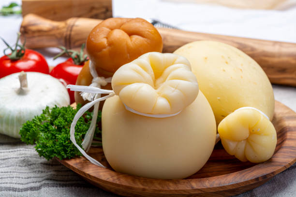 italiano provolone o provola caciocavallo formaggi duri e affumicati in forma di lacrima servita sulla tavola dell'ulivo da vicino - trapani close up sicily italy foto e immagini stock