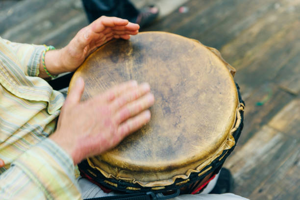 istock Man playing the djembe african drum outdoors wood 1163976679