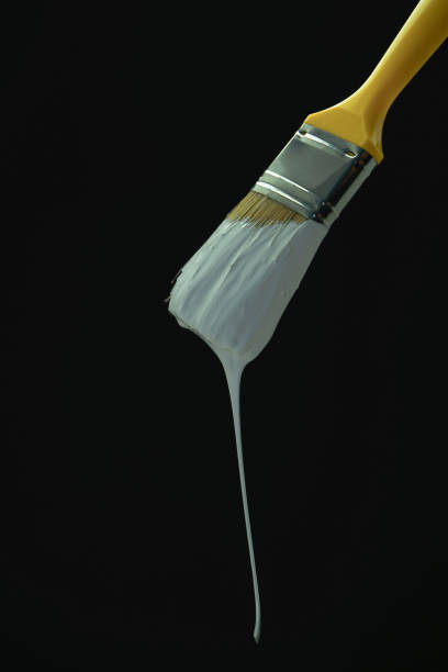 istock Dripping white paint brush on a blackbackground. 1163978001