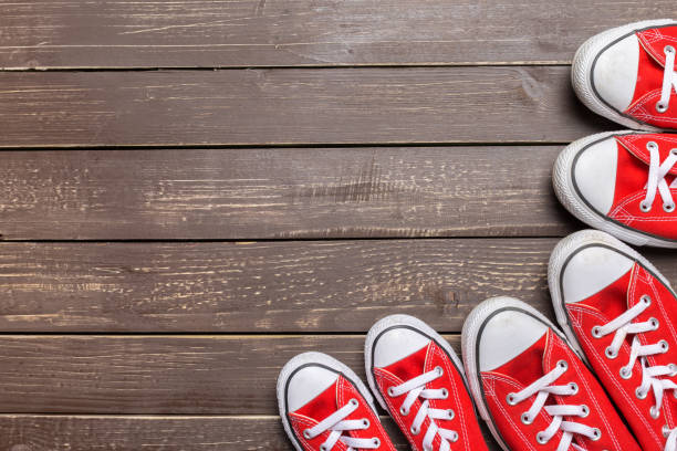 istock red sneakers on wooden background. 1163978886