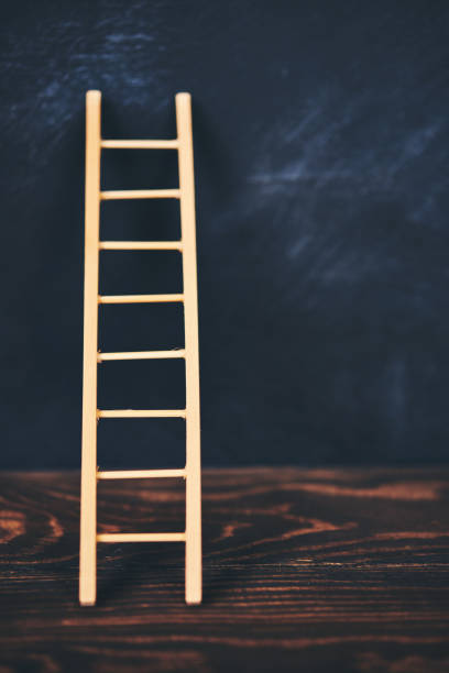 istock Ladder leaning against blank chalkboard 1163979138