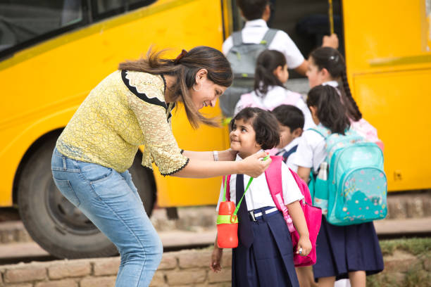 istock Teacher talking with student before they get on school bus 1163980859