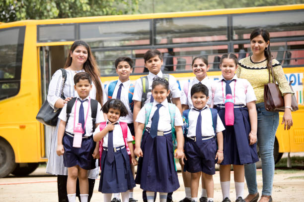 istock Group of school children with teachers standing in group 1163982528