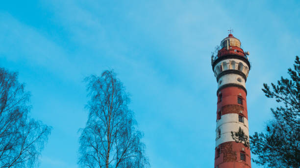istock Lighthouse in the forest among the trees. red and white lighthouse 1163982609