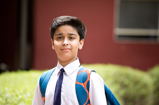 Portrait of Indian schoolboy standing at school campus