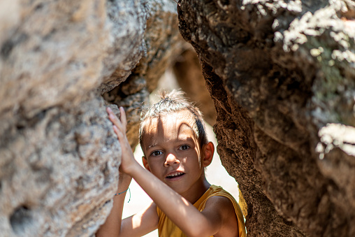 little boy between the rocks