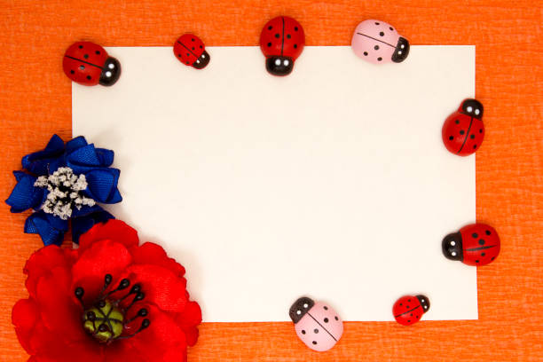 Decoration with ladybirds and ribbon against wooden background with copy space