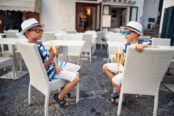 Two little boys eating bananas