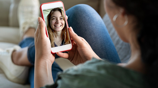 Mujer joven usando el teléfono inteligente para videollamada photo