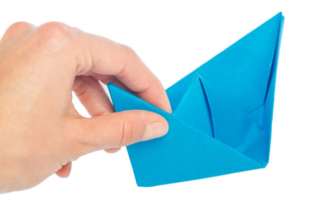 istock Paper ship in a female hand 1163988962