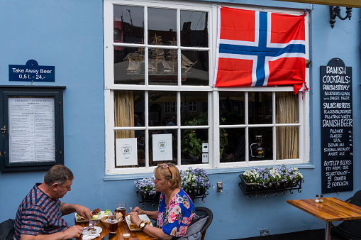Copenhagen, Denmark - May 18, 2019: Tourists having lunch at vintage old fashioned restaurant at famous Nyhavn pier in Copenhagen