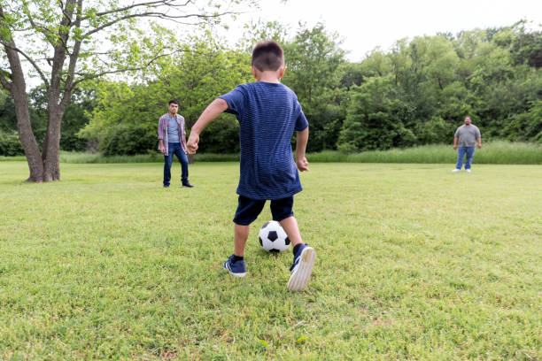 istock Little boy kicking soccer ball 1163991399