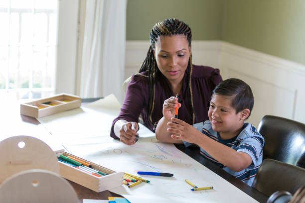 istock Therapist works with young boy with Down Syndrome 1163992060