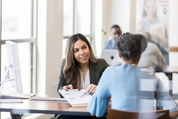 istock Loan officer explains loan application form to mature female customer 1163992156