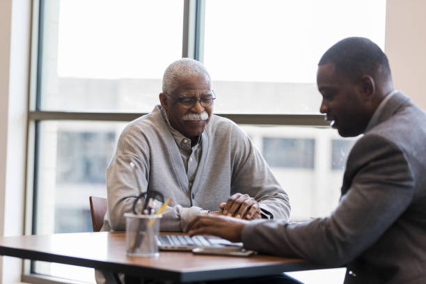 il funzionario del prestito per adulti medio aiuta l'uomo anziano a trovare il miglior investimento - retirement senior adult planning finance foto e immagini stock