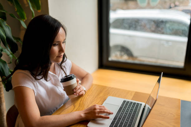 istock Female college student uses computer in coffee shop 1163992227