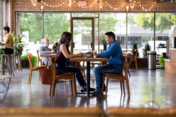 istock Couple have coffee together in trendy cafe 1163992317