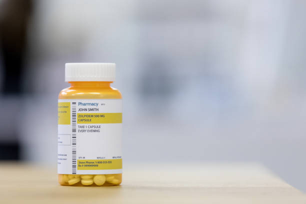 Prescription sleep aid on the counter in a pharmacy. Focus is on the bottle of tablets.