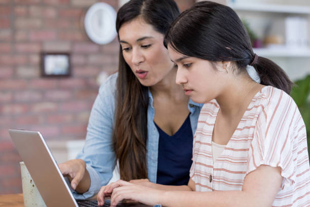 istock Mom and daughter look at something on computer 1163992539