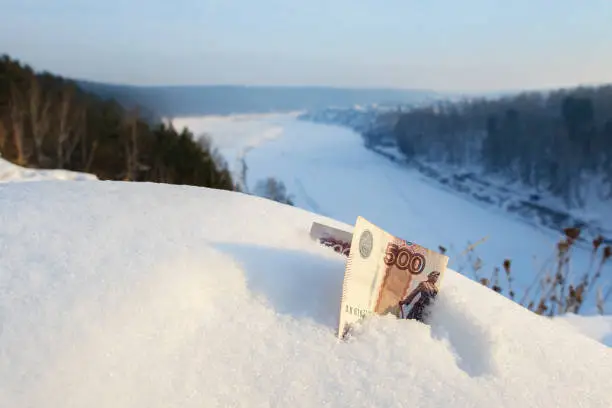 500 rubles Russian money in the snow on the background of forests and snowy rivers, the view from the mountain
