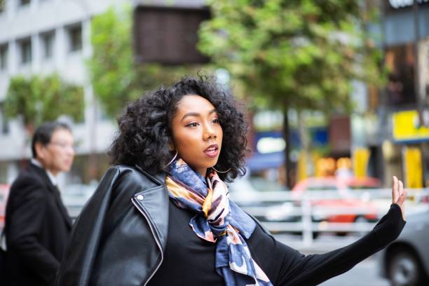 istock Young woman hailing a cab 1163996215