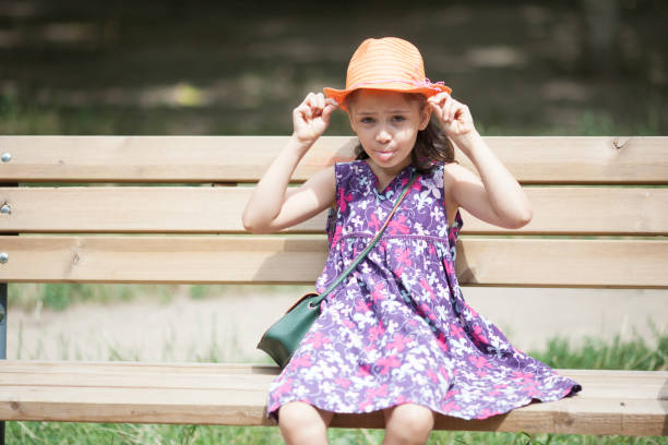 Model in nature resting on bench. Looking away