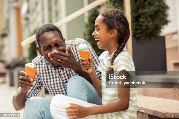 Positive Delighted International Male Person Eating Icecream Stock Photo - Download Image Now