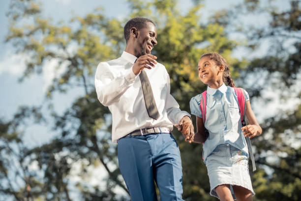 istock Joyful father and daughter walking hand in hand after classes 1163999390