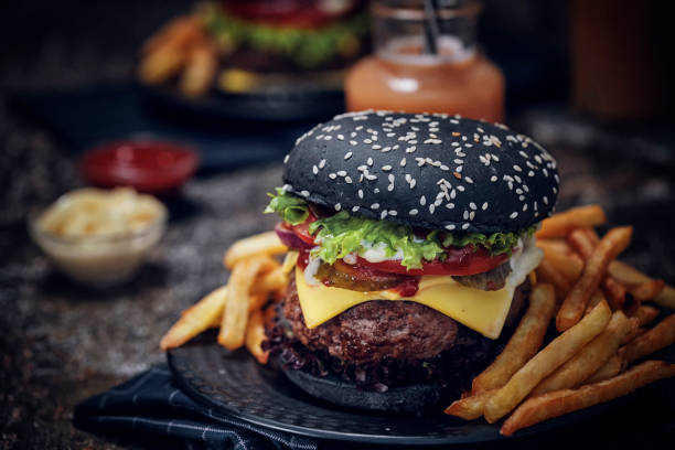 istock Black Burger Buns with Beef Pattie, Cheese, Tomato and Lettuce 1164000866